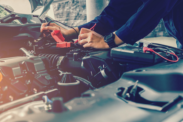 Mechanic working on battery of a vehicle