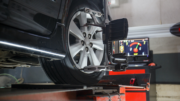 Wheel Alignment tool attached to wheel of a black vehicle
