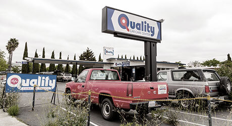 Vehicles parked outside near sign stating Quality Tune-Up Car Care