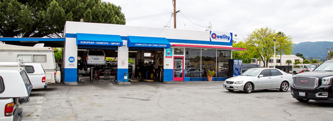 Outside of shop with vehicles parked outside | Quality Tune-Up Auto Care