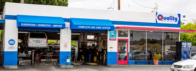 Close-up of outside of shop, vehicle in repair | Quality Tune-Up Auto Care