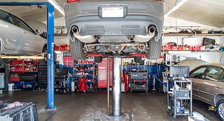 Vehicles parked outside near sign stating Quality Tune-Up Car Care