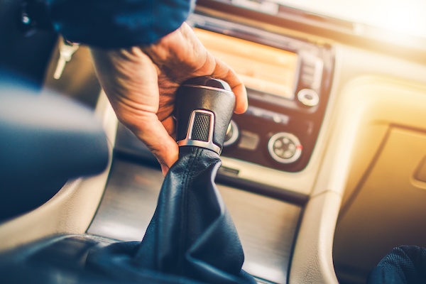 Man's handing using a stick shift in a vehicle